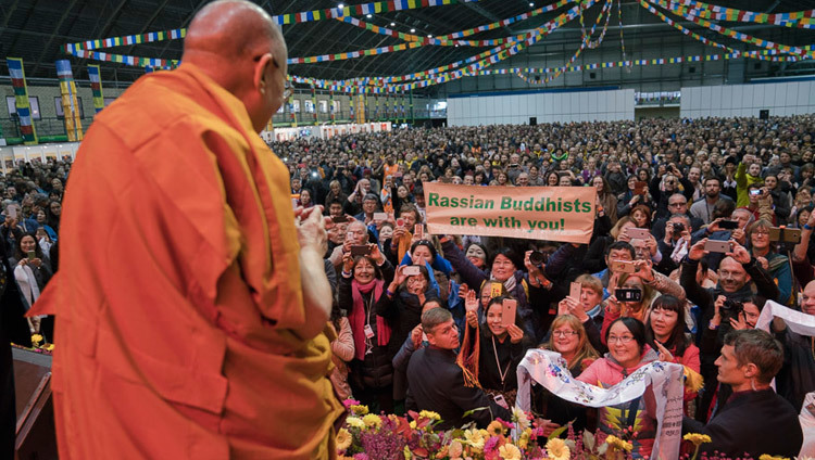 His Holiness the Dalai Lama greeting the audience of 4500 on his arrival on stage at the start of his teaching at Skonto Hall in Riga, Latvia on October 10, 2016. Photo/Tenzin Choejor/OHHDL