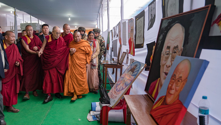 His Holiness the Dalai Lama looking at results of a student competition to portray him as he arrives at the Kalachakra teaching ground in Bodhgaya, Bihar, India on December 31, 2016. Photo/Tenzin Choejor/OHHDL