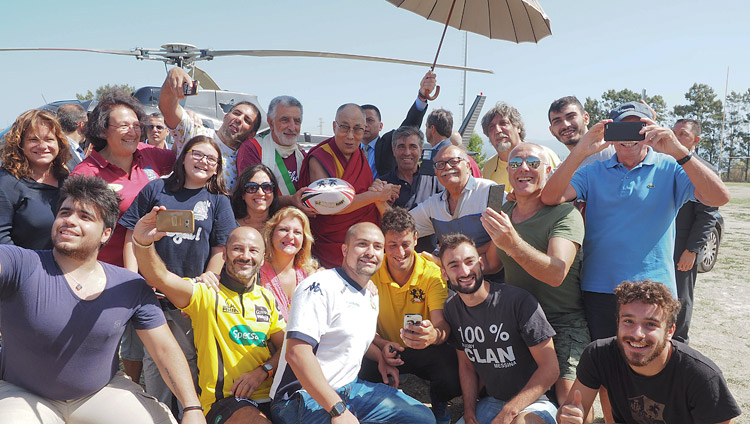 His Holiness the Dalai Lama with members of the Sunday rugby club on the field used as a helipad for his trip to Palermo from Messina, Sicily, Italy on September 17, 2017. Photo by Jeremy Russell