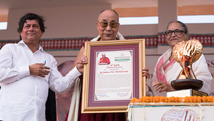 His Holiness the Dalai Lama holding the KISS Humanitarian Award presented to him at KISS University in Bhubaneswar, Odisha, India on November 21, 2017. Photo by Tenzin Choejor