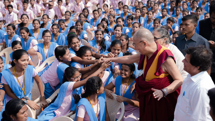 His Holiness the Dalai Lama reaching out to some of the more than 25,000 students gathered at KISS University for the KISS Humanitarian Award presentation in Bhubaneswar, Odisha, India on November 21, 2017. Photo by Tenzin Choejor