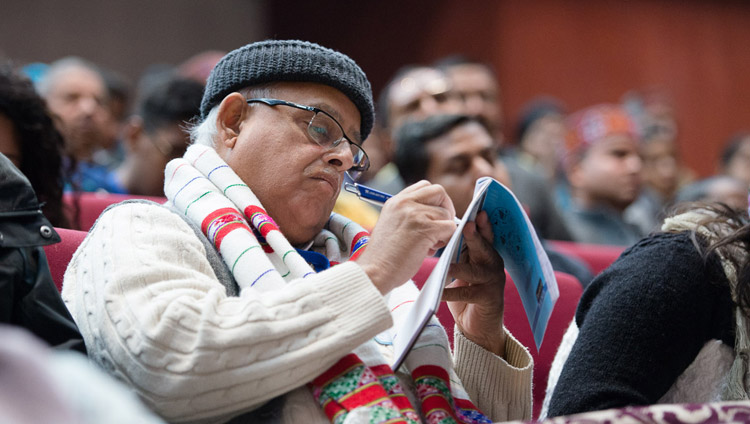A member of the audience taking notes as His Holiness the Dalai Lama addresses the Convention for Global Peace at the Government College in Dharamsala, HP, India on December 2, 2017. Photo by Lobsang Tsering A member of the audience taking notes as His Holiness the Dalai Lama addresses the Convention for Global Peace at the Government College in Dharamsala, HP, India on December 2, 2017. Photo by Lobsang Tsering