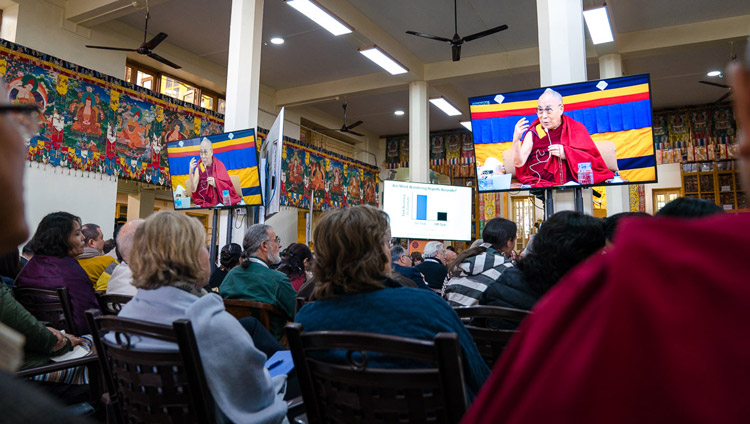 Some of the over 300 guests attending the Mind & Life Conference watching His Holiness the Dalai Lama on TV screens at the Main Tibetan Temple in Dharamsala, HP, India on March 14, 2018. Photo by Tenzin Choejor