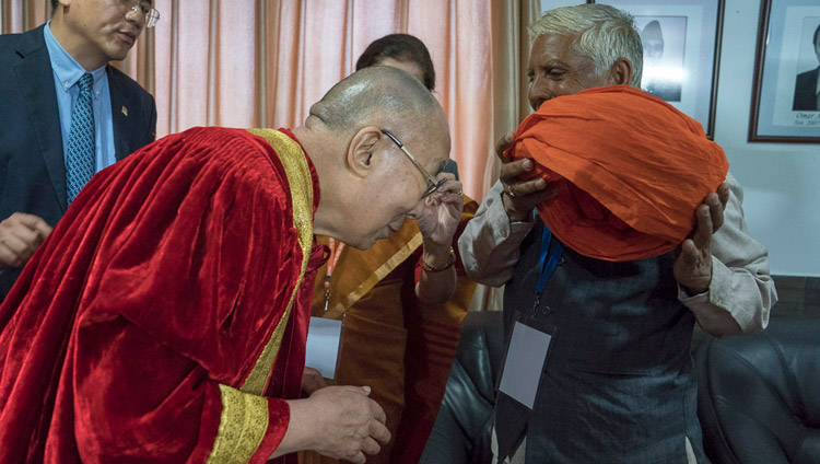 His Holiness the Dalai Lama putting on academic robes before proceeding to the First Convocation of the Central University of Jammu in Jammu, J&K, India on March 18, 2018. Photo by Tenzin Choejor