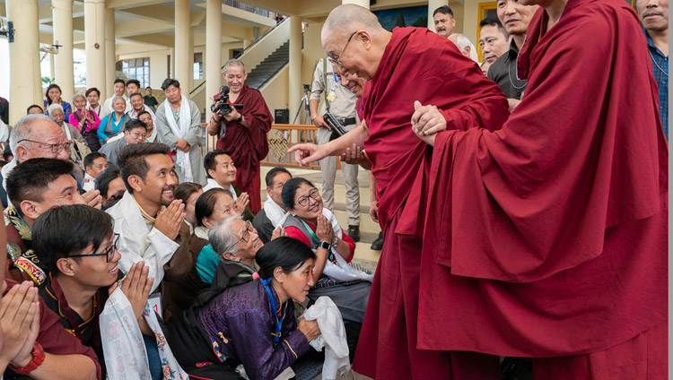 His Holiness the Dalai Lama greeting members of the audience as he departs for his residence at the conclusion of his meeting with participants to an International Conference on the Middle Way Approach at the Main Tibetan Temple courtyard in Dharamsala, HP, India on May 30, 2018. Photo by Tenzin Choejor