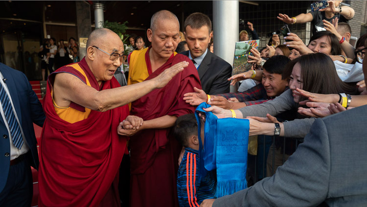 His Holiness the Dalai Lama greeting well wishers as he leaves his hotel on the way to Skonto Hall in Riga, Latvia on June 17, 2018. Photo by Tenzin Choejor