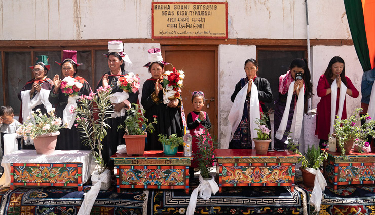 Local people standing alongside carved table bearing potted flowers to welcome Holiness the Dalai Lama to Nubra Valley in Ladakh, J&K, India on July 12, 2018. Photo by Tenzin Choejor
