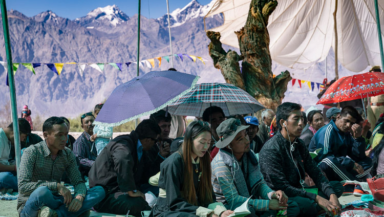 Mountains rise up from Nubra Valley in the background as members of the audience listen to His Holiness the Dalai Lama's teaching at Samstanling Monastery in Sumur, Nubra Valley, Ladakh, J&K, India on July 16, 2018. Photo by Tenzin Choejor