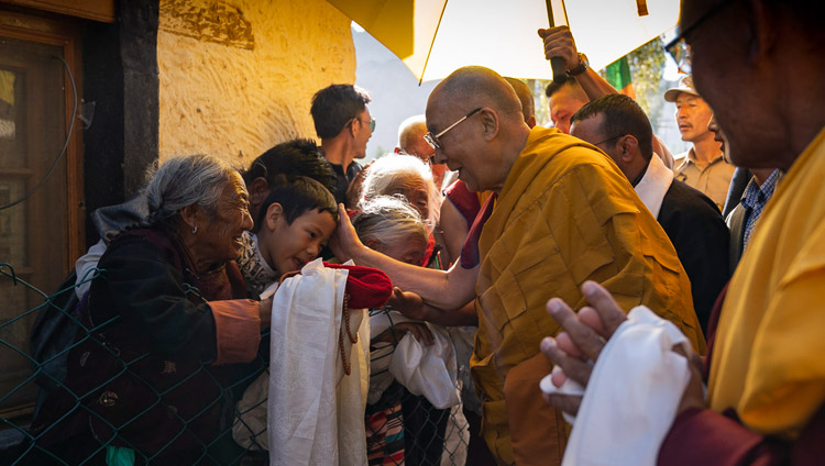 His Holiness the Dalai Lama greeting well-wishers as he walks from his residence to the Shiwatsel Teaching Ground in Leh, Ladakh, J&K, India on July 31, 2018. Photo by Tenzin Choejor