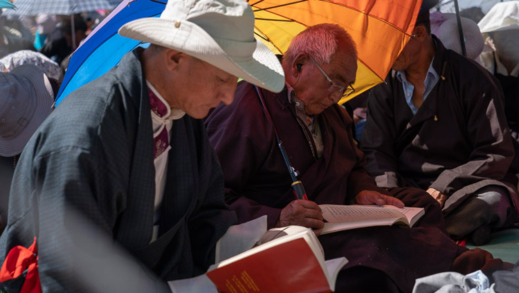 Members of the crowd following the text during His Holiness the Dalai Lama's final day of teachings in Leh, Ladakh, J&K, India on July 31, 2018. Photo by Tenzin Choejor