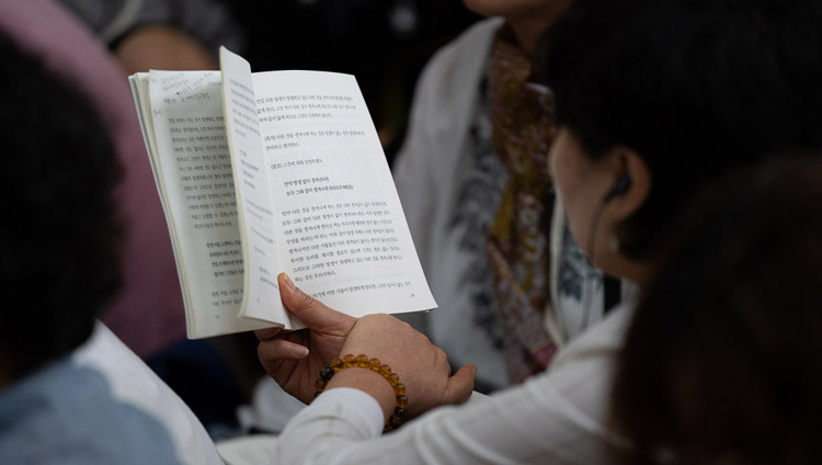A member of the audience following the text during the second day of His Holiness the Dalai Lama's teachings at the Main Tibetan Temple in Dharamsala, HP, India on September 5, 2018. Photo by Tenzin Choejor A member of the audience following the text during the second day of His Holiness the Dalai Lama's teachings at the Main Tibetan Temple in Dharamsala, HP, India on September 5, 2018. Photo by Tenzin Choejor