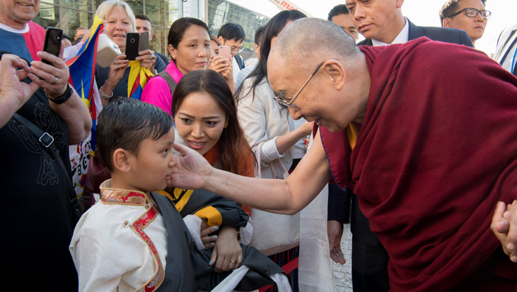 His Holiness the Dalai Lama greeting a young boy as he arrives at his hotel in Darmstadt, Germany on September 18, 2018. Photo by Manuel Bauer