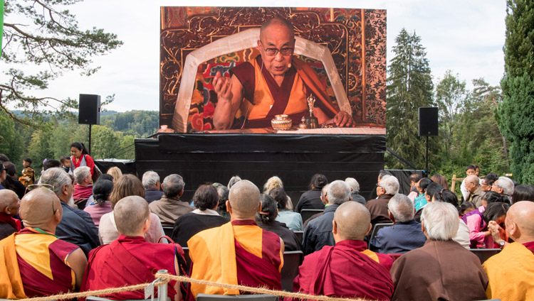 Members of the crowd watching His Holiness the Dalai Lama on a big screen outside the temple during the ceremony commemorating Tibet Institute Rikon's 50th anniversary in Rikon, Switzerland on September 21, 2018. Photo by Manuel Bauer