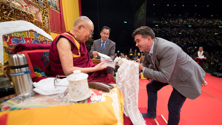 Daniel Aitken, President of Wisdom Books, requesting His Holiness to release the paperback edition of ‘The Life of My Teacher: A Biography of Kyabjé Ling Rinpoché’ at the conclusion of teachings at the Zurich Hallenstadion in Zurich, Switzerland on September 23, 2018. Photo by Manuel Bauer