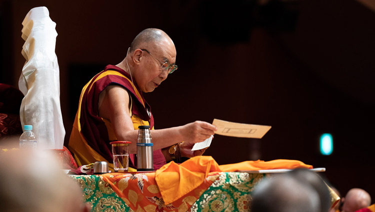 His Holiness reading from the text on the first day of his teaching in Yokohama, Japan on November 14, 2018. Photo by Tenzin Choejor