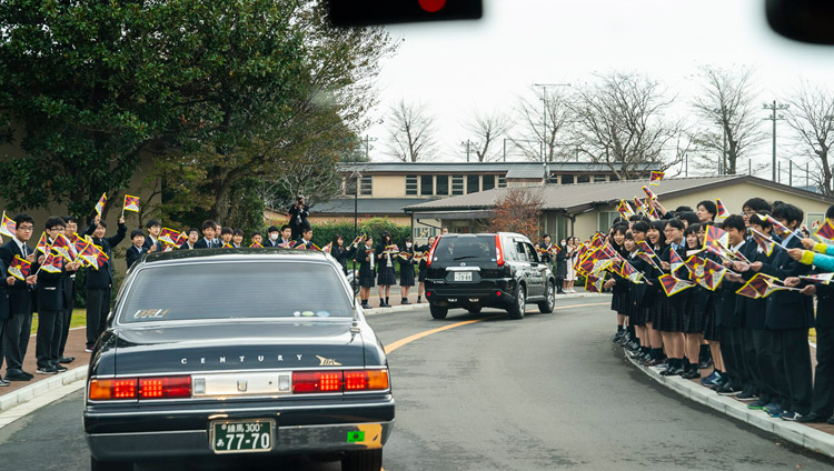 Students and staff smiling and waving Tibetan flags welcome His Holiness the Dalai Lama on his arrival at Reitaku University in Chiba, Japan on November 19, 2018. Photo by Tenzin Choejor