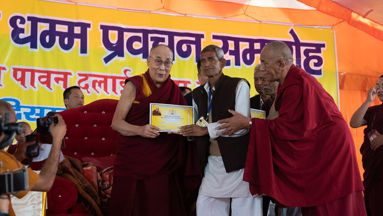 His Holiness the Dalai Lama presenting certificates of appreciation to the organizers of his three day teaching in Sankisa, UP, India on December 5, 2018. Photo by Lobsang Tsering