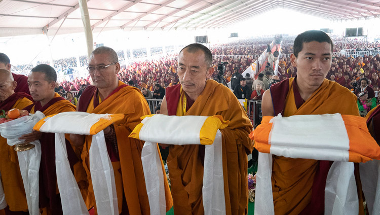 Namgyal Monastery monks in the offering procession passing before His Holiness the Dalai Lama during the Long Life Ceremony at the Kalachakra Ground in Bodhgaya, Bihar, India on December 31, 2018. Photo by Lobsang Tsering