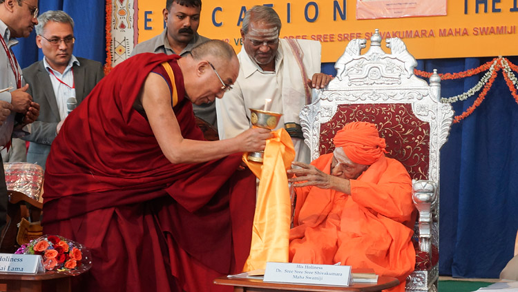 His Holiness the Dalai Lama offering a butter lamp to Sree Shivakumara Swamiji during his visit to Tumkur University in Tumkar, Karnataka, India on November 27, 2012. Photo by Jeremy Russell