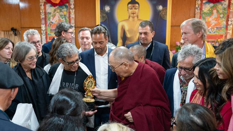 The audience gathers around His Holiness the Dalai Lama as he presents a Dharma Wheel to Deepak Chopra at the conclusion of their meeting in Dharamsala, HP, India on February 11, 2019. Photo by Tenzin Choejor