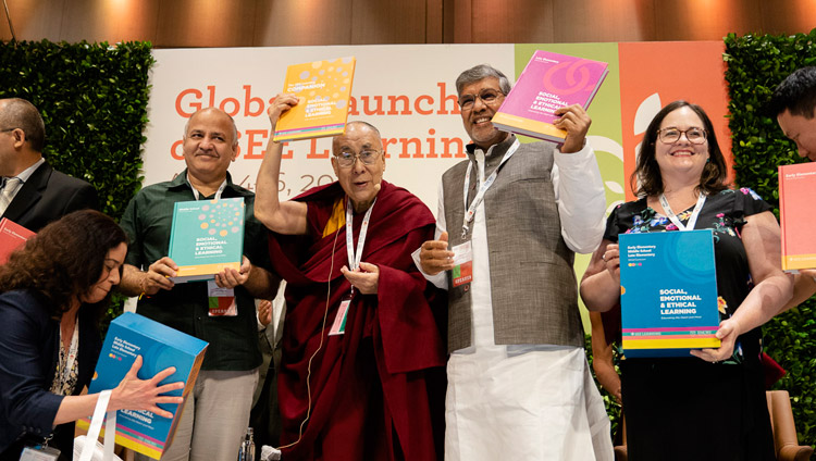 His Holiness the Dalai Lama with Delhi Deputy Chief Minister Manish Sisodia and Nobel Peace Laureate Kailash Satyarthi holding the SEE Learning curriculum text books in New Delhi, India on April 5, 2019. Photo by Tenzin Choejor