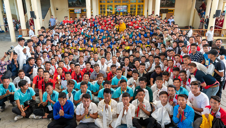 His Holiness the Dalai Lama poses with the 23 teams of young Tibetans from Europe, America and many parts of India, who are participating in the 25th Gyalyum Chenmo Memorial Gold Cup football tournament in the Main Tibetan Temple courtyard in Dharamsala, HP, India on June 5, 2019. Photo by Tenzin Choejor