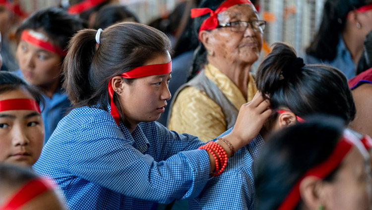 Tibetan students in the audience preparing ritual blindfolds used in the Avalokiteshvara Empowerment given by His Holiness the Dalai Lama at the Main Tibetan Temple in Dharamsala, HP, India on June 5, 2019. Photo by Tenzin Choejor