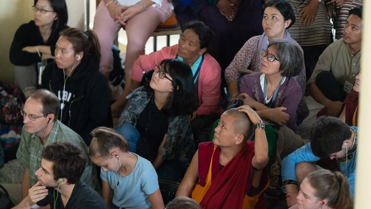 Members of the audience sitting on the veranda outside the Main Tibetan Temple watching His Holiness the Dalai Lama on a TV screen during the first day of his teachings in Dharamsala, HP, India on September 4, 2019. Photo by Tenzin Choejor