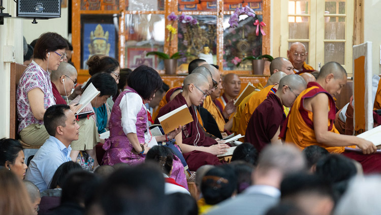 Members of the audience following the text as His Holiness the Dalai Lama reads from Nagarjuna's ‘Commentary on the Awakening Mind' on the second day of his teachings at the Main Tibetan Temple in Dharamsala, HP, India on September 5, 2019. Photo by Tenzin Choejor