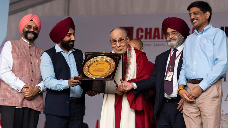 His Holiness the Dalai Lama holding plate symbolizing the Global Leadership Award presented to him by Chandigarh University in Chandigarh, India on October 15, 2019. Photo by Tenzin Choejor