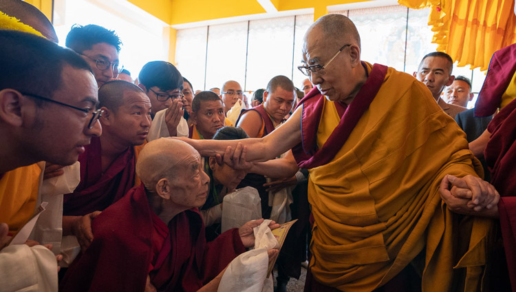 His Holiness the Dalai Lama greeting members of the congregation as he enters the assembly hall at Gyutö Tantric College in Dharamsala, HP, India on November 2, 2019. Photo by Tenzin Choejor