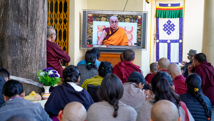 Members of the audience sitting on the veranda at the backside of the Main Tibetan Temple watching His Holiness the Dalai Lama on a TV during the first day of teachings requested by a group from Korea in Dharamsala, HP, India on November 4, 2019. Photo by Ven Tenzin Jamphel