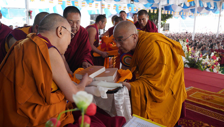 The Abbot of Namgyal Monastery, Thomtog Rinpoché, presenting the most recent publications of the works on Science and Philosophy in the Indian Buddhist Classics to His Holiness the Dalai Lama during the celebration of Ganden Ngamchö in Mundgod, Karnataka, India on December 21, 2019. Photo by Lobsang Tsering