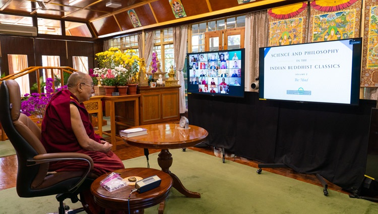 His Holiness the Dalai Lama looking at a close up of the newly released English translation of the second volume of the series Science and Philosophy in the Indian Buddhist Classics on a TV at his residence in Dharamsala, HP, India at the start of the virtual book launch on November 13, 2020. Photo by Ven Tenzin Jamphel