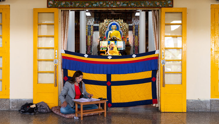 The Portuguese interpreter sitting outside the Main Temple translating His Holiness the Dalai Lama's live teaching in Dharamsala, HP, India on May 16, 2020. Photo by Lobsang Tsering