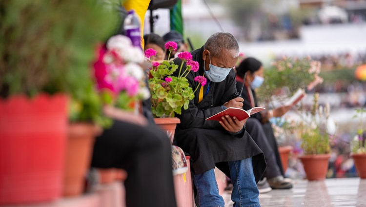 Miembros del público siguiendo el texto mientras Su Santidad el Dalái Lama lee «El Modo de Vida de los Bodisatvas» de Shantideva en el segundo día de enseñanzas en el Campo de Enseñanza de Shewatsel en Leh, Ladakh, UT, India el 29 de julio de 2022. Foto de Tenzin Choejor
