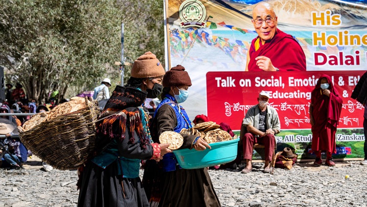 Unas mujeres llevan pan para distribuirlo entre los más de 4000 estudiantes y miembros de la comunidad local que asisten a la charla de Su Santidad el Dalái Lama en el campo de enseñanza de Padum, Zanskar, Ladakh, UT, India, el 13 de agosto de 2022. Foto de Tenzin Choejor