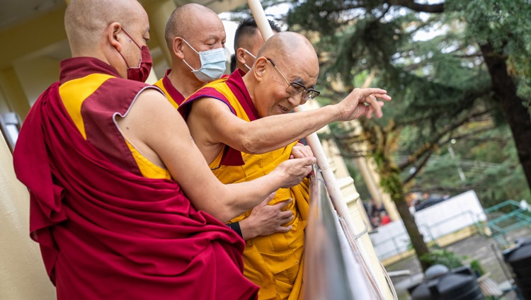His Holiness the Dalai Lama waving to people gathered on the street below as makes his way around the Kalachakra Temple in Dharamsala, HP, India on September 16, 2022. Photo by Tenzin Choejor