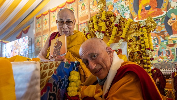 Ratö Khensur, Nicholas Vreeland, presenting His Holiness the Dalai Lama with the first copy of a newly published book that contains His Holiness’s spiritual biography composed by the late Ratö Khyongla Rinpoché at the start of the second day of teachings in Bodhgaya, Bihar, India on December 30, 2022. Photo by Tenzin Choejor