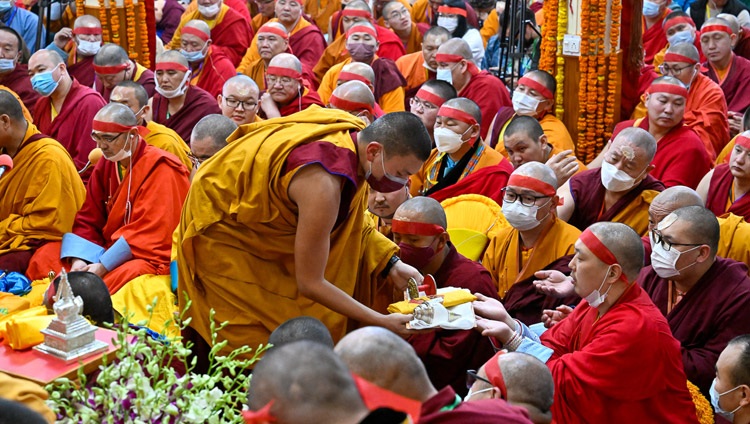 Monjes caminando entre la multitud llevando objetos rituales de la iniciación Chakrasamva conferida por Su Santidad el Dalái Lama en el Tsulagkhang de Dharamsala, HP, India, el 9 de marzo de 2023. Foto de Ven Zamling Norbu