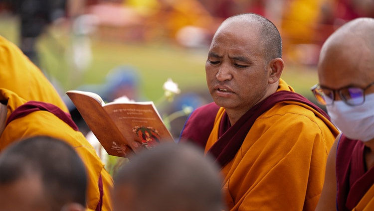 Un monje en la audiencia siguiendo el texto «Treinta y siete prácticas de todos los bodisatvas» en el primer día de la enseñanza de Su Santidad el Dalái Lama en el Área de Enseñanza de Shewatsel en Leh, Ladakh UT, India el 21 de julio de 2023. Foto de Tenzin Choejor