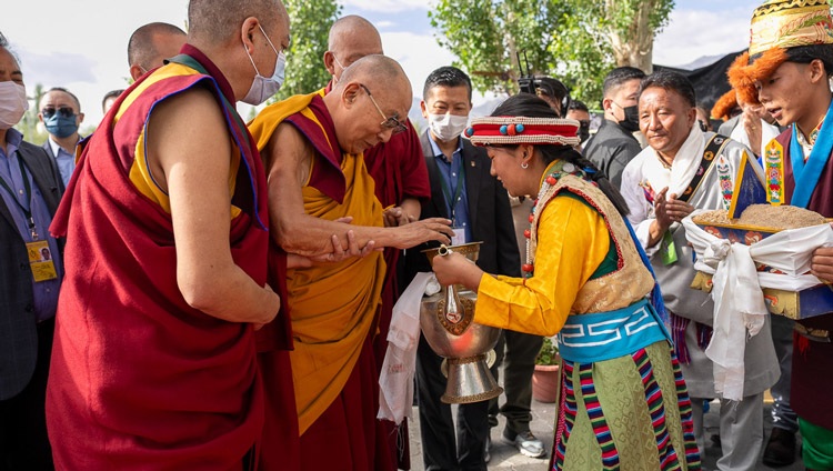 Su Santidad el Dalái Lama recibe una bienvenida tradicional a su llegada para su charla a la comunidad tibetana de Ladakh en la Escuela de la Aldea Infantil Tibetana (TCV) Choglamsar en Leh, Ladakh, India, el 26 de julio de 2023. Foto de Tenzin Choejor