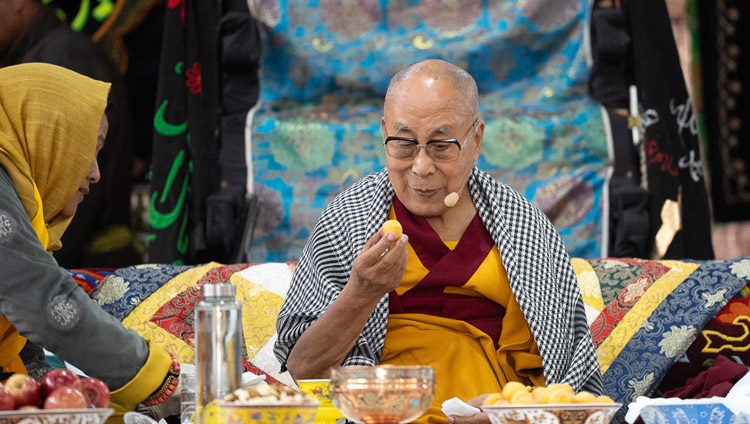 is Holiness the Dalai Lama about to take a bite of apricot during his talk to members of the Muslim community at Imam Bargah, Chuchot Yokma, in Leh, Ladakh, India on August 12, 2023. Photo by Tenzin Choejor