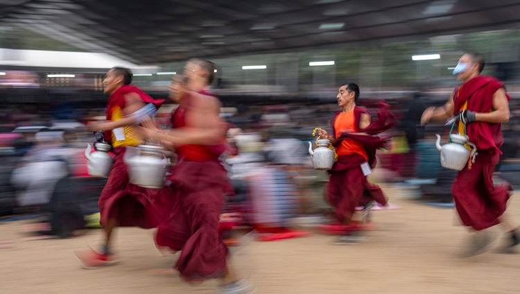 Volunteer monks racing to serve tea to the crowd of over 50,000 attending the second day of His Holiness the Dalai Lama's teachings at the Kalachakra Ground in Bodhgaya, Bihar, India on December 30, 2023. Photo by Tenzin Choejor