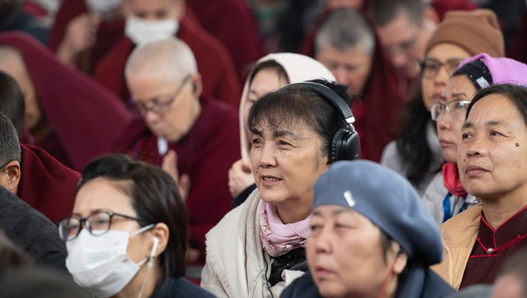 Members of the crowd, some listening to translations, watching the proceedings during the Long Life Prayer offered to His Holiness the Dalai Lama at the Kalachakra Ground in Bodhgaya, Bihar, India on January 1, 2024. Photo by Ven Zamling Norbu